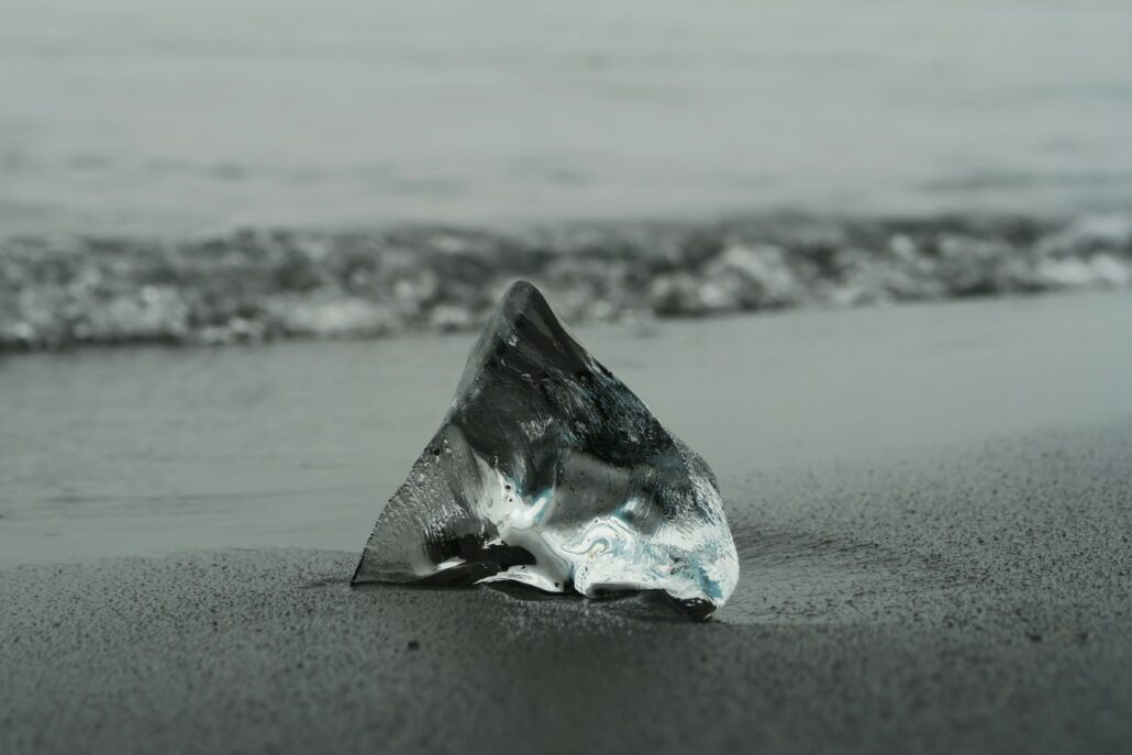 Ein einzelner, teilweise im Sand vergrabener Diamant, der den wertvollen schlafenden Bestand im Gesamtlager eines Unternehmens repräsentiert.
